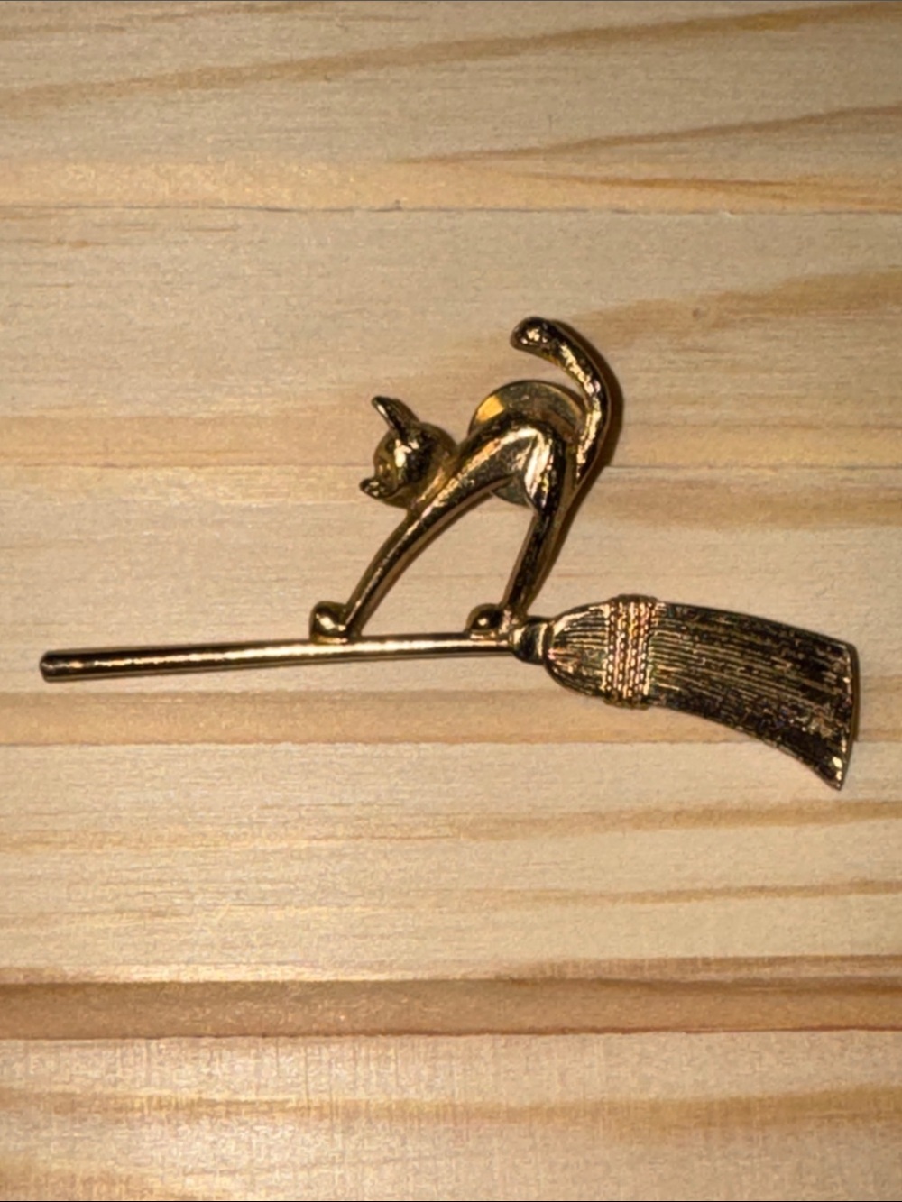 1989 vintage gold-tone Avon cat on a broomstick lapel pin.